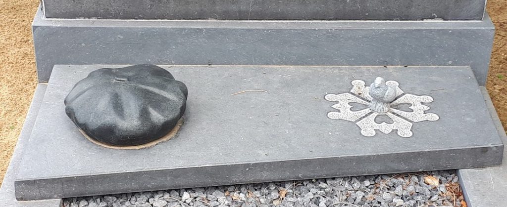 Alpinopet en duif op grafzerk