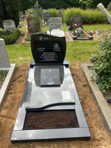 Enkel grafmonument met golfvormige afdekplaat en extra gedenktegel