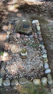 Natuurgraf met ruwe steen en omranding van keien