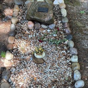 Natuurgraf met ruwe steen en omranding van keien