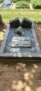 Natuurlijk grafmonument met ruwe stenen en inscriptieplaat