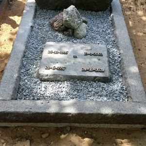 Natuurlijk grafmonument met ruwe stenen en inscriptieplaat